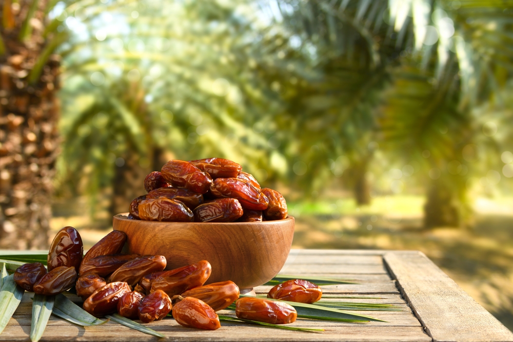 Dried,Dates,Fruits,With,Dates,Palm,Plantation,Background.